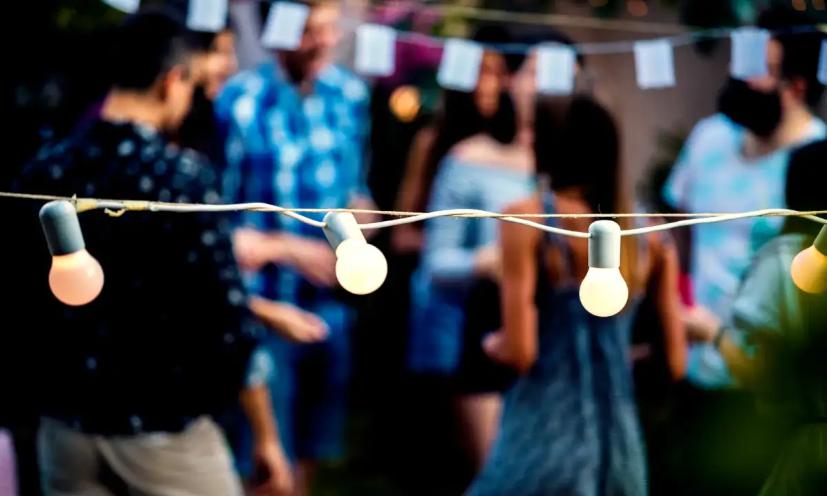 Neighbors gathered under string lights at a block party