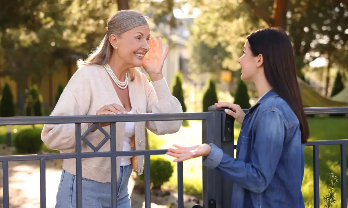 Two neighbors talking across a fence