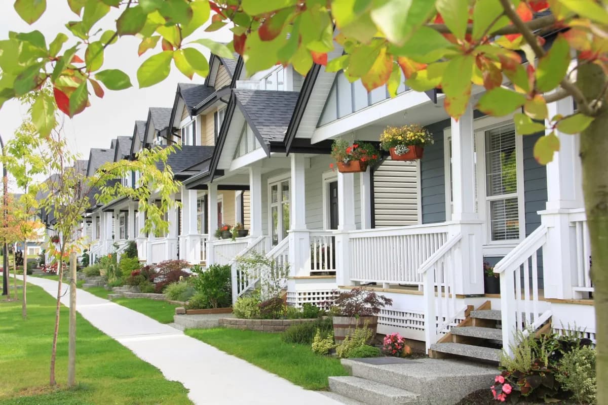 A row of homes with front porches and leafy trees
