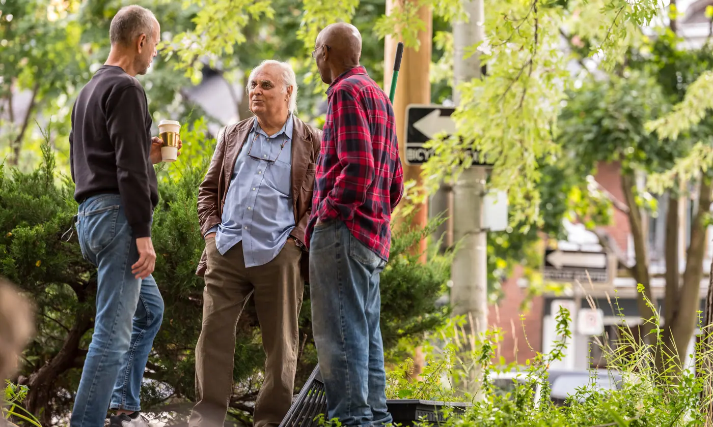 Three older neighbors enjoying a conversation outdoors