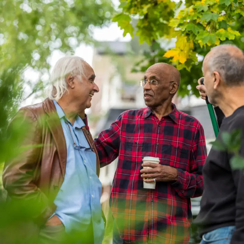 Three older neighbors chatting over coffee