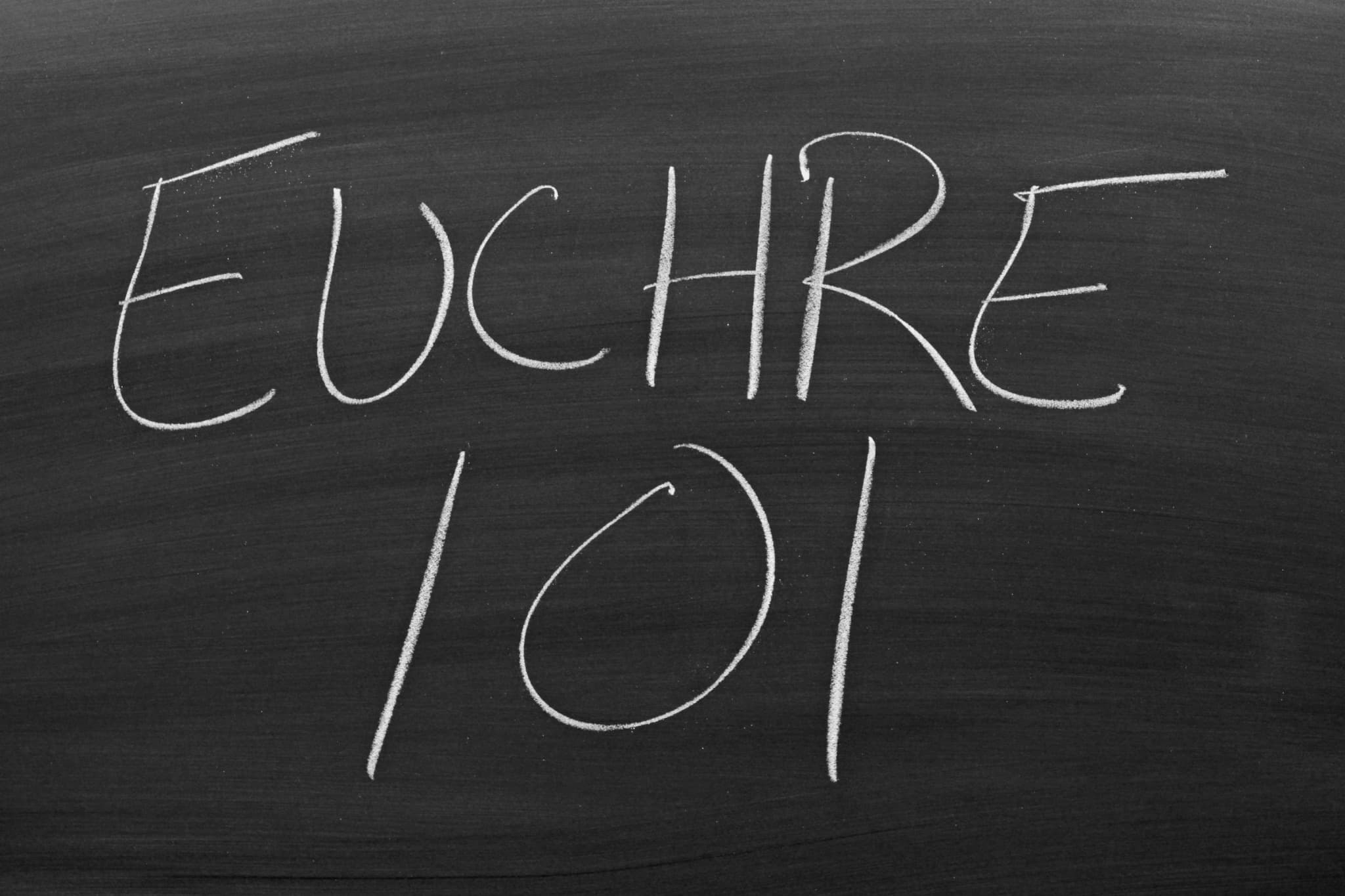 Euchre 101 written in chalk on a blackboard.