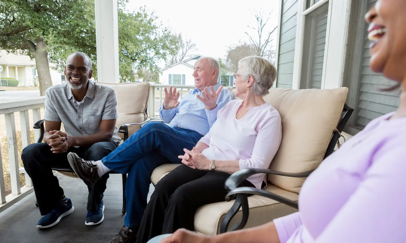 Neighbors talking together on a porch